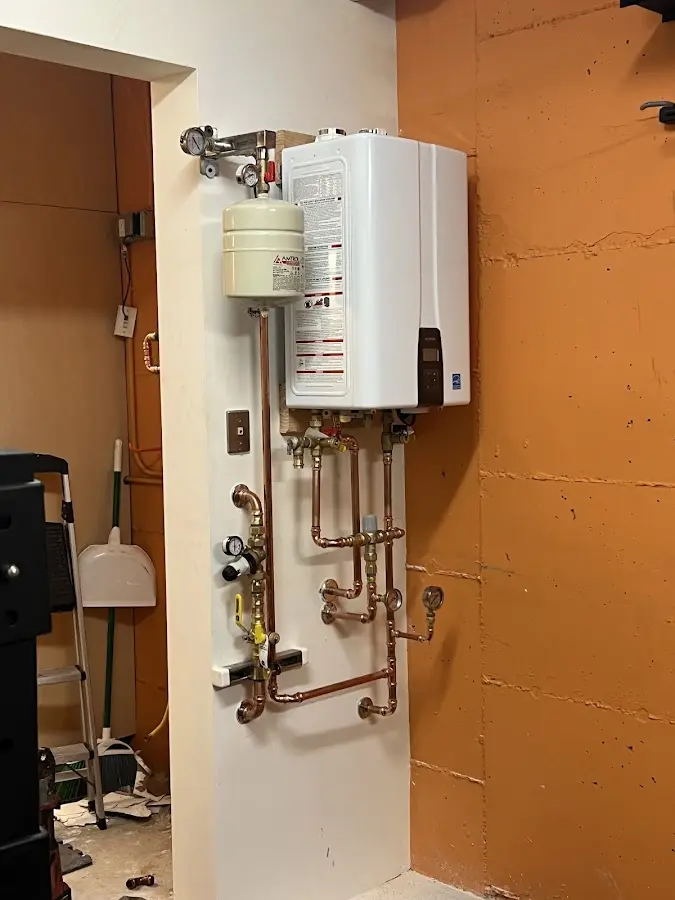 Plumbing technician inspecting water heater connections in Bridgeton